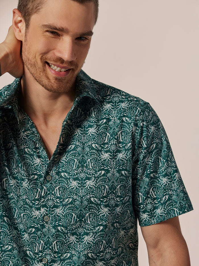 Green damask-print cotton lawn shirt, relaxed fit, front view with model’s hand behind neck.