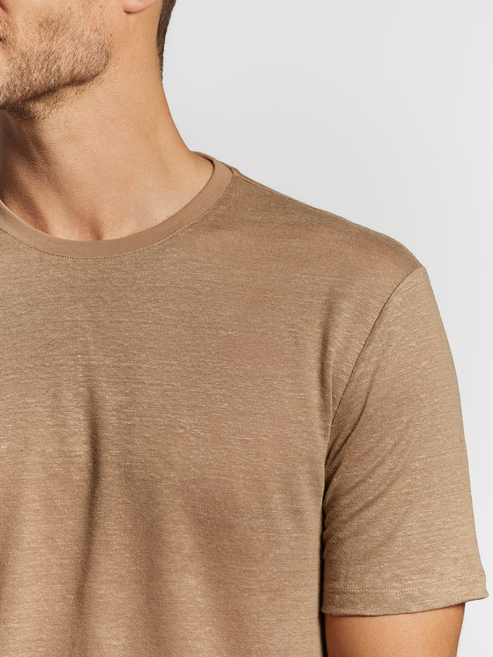 Light brown solid T-shirt, upper body partial side view of man facing left.