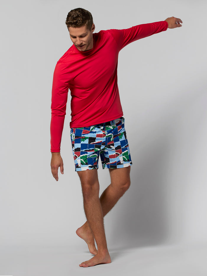 Red short-sleeve shirt, gray shorts, man standing on one foot, plain background in both images.