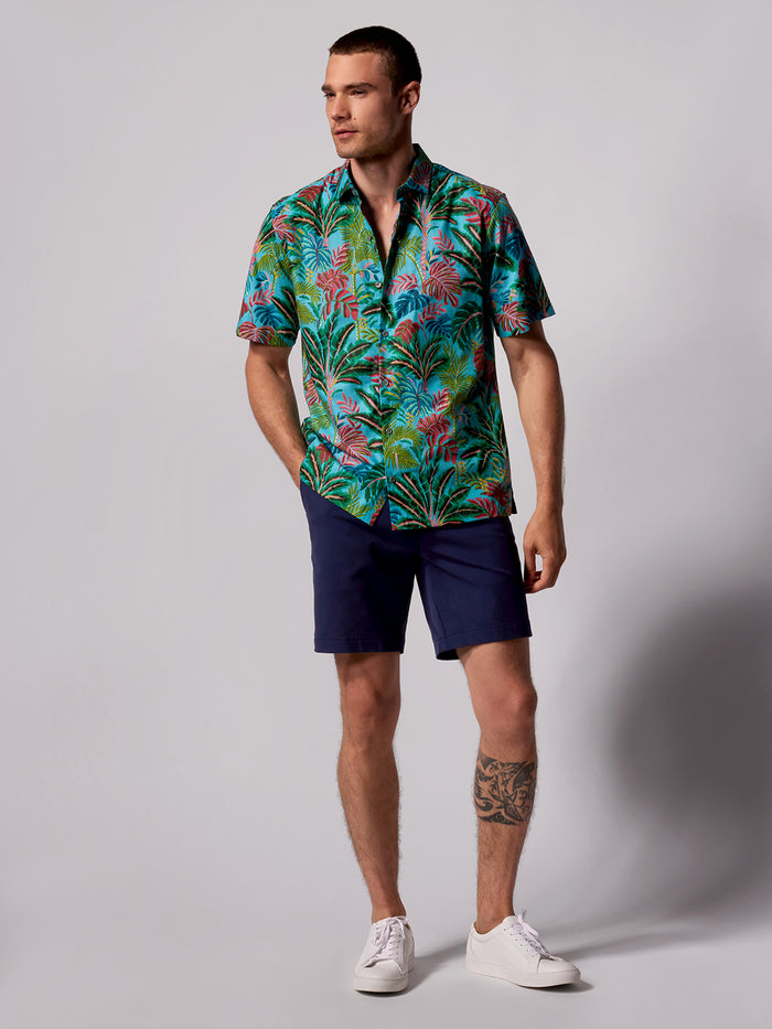 Multi-color tropical-print short-sleeve shirt and navy shorts, full outfit front view.