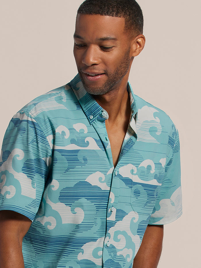 Blue wave-print short-sleeve shirt with front pocket , front view of man smiling against beige background.