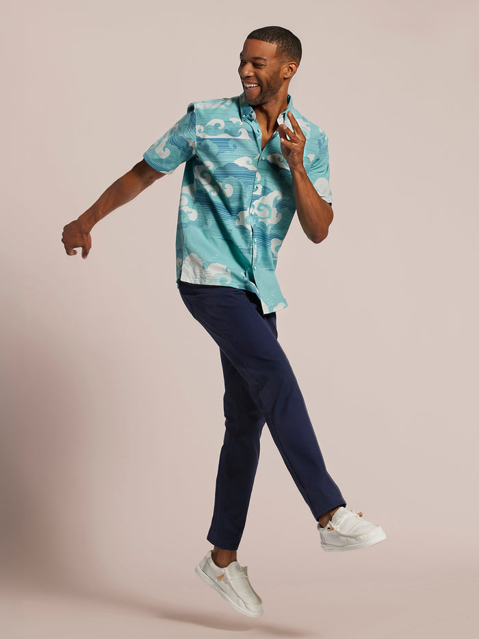 Light blue short-sleeve shirt, navy pants, dynamic pose, front view.