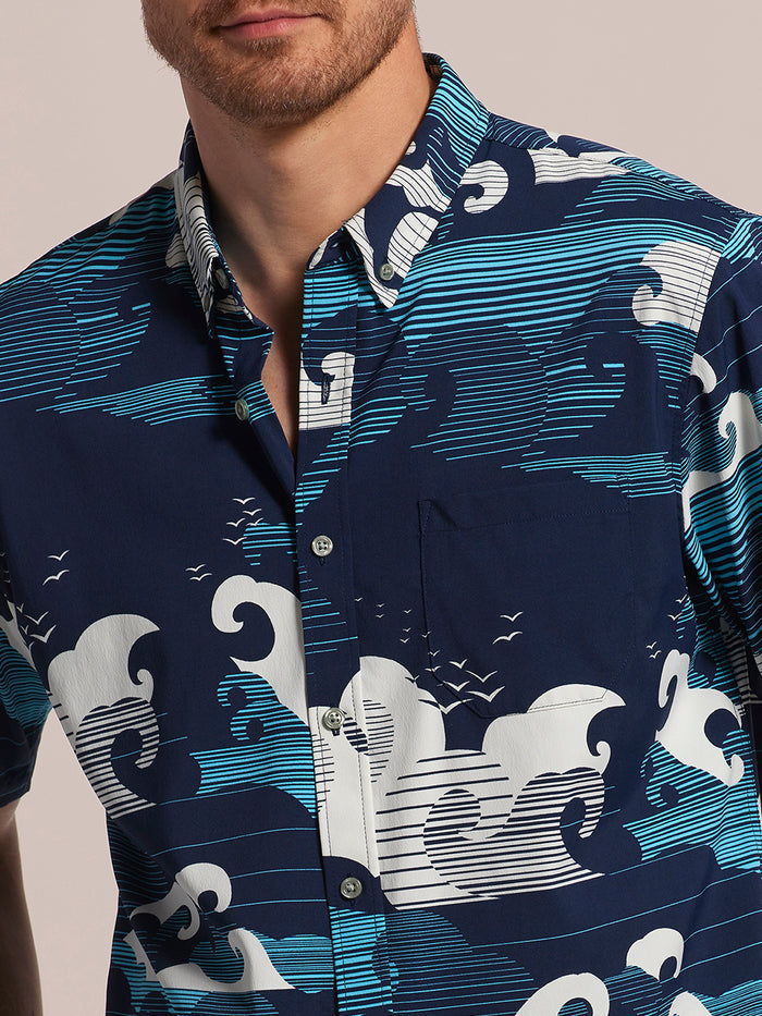 Front views of a blue ocean waves-print short-sleeve shirt worn by a man.