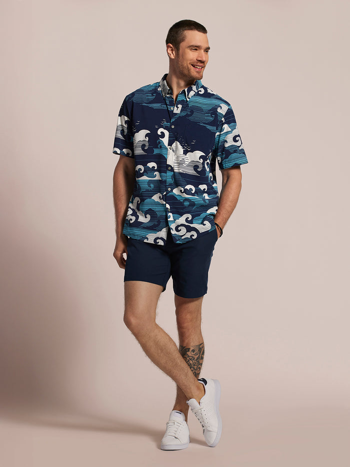 Blue wave-print short-sleeve shirt and navy shorts, front view.