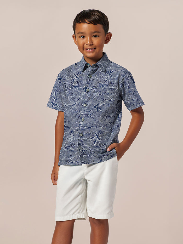 Blue and white wave-print short-sleeve shirt with white shorts, front view.