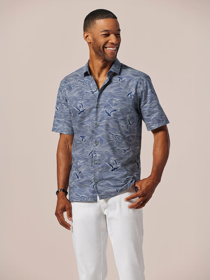 Navy color, whale-print short-sleeve shirt, front view on smiling man against light background.