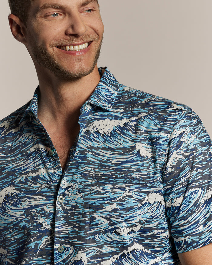 Blue wave-print cotton shirt, chest-up front view of smiling man.