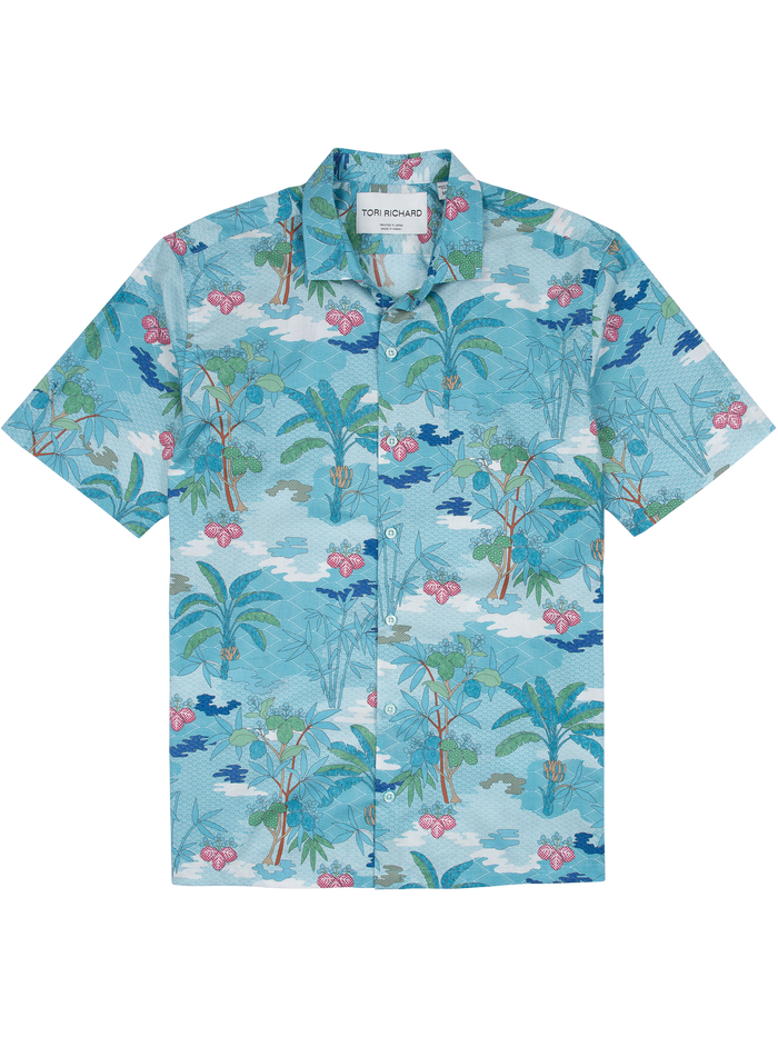 Blue cotton shirt with palm tree, pink flower, and bird print, front view.